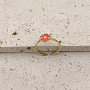 Craquante cette bague en acier inoxydable doré pour petite fille est ornée d’une jolie fleur rouge façon marguerite.
