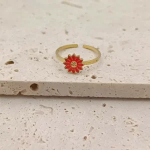 Craquante et pleine de pep’s, cette bague en acier inoxydable doré est ornée d’une jolie fleur rouge façon marguerite.