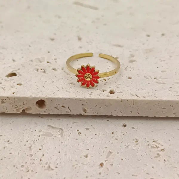 Craquante et pleine de pep’s, cette bague en acier inoxydable doré est ornée d’une jolie fleur rouge façon marguerite.