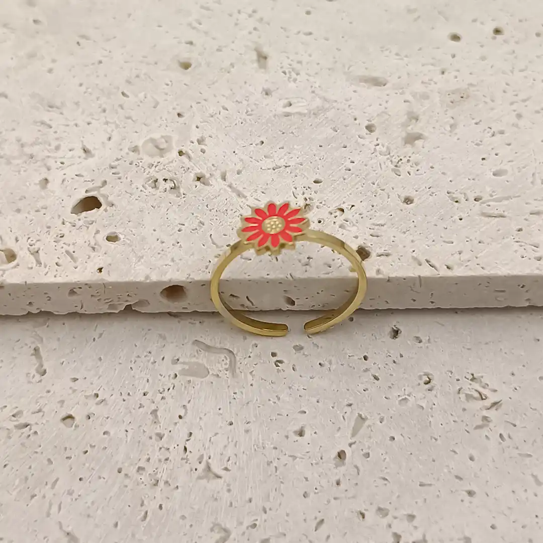 Craquante cette bague en acier inoxydable doré pour petite fille est ornée d’une jolie fleur rouge façon marguerite.