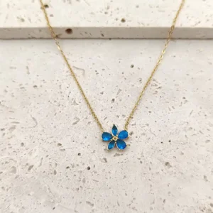 Collier femme doré en acier avec pendentif fleur en verre bleu.