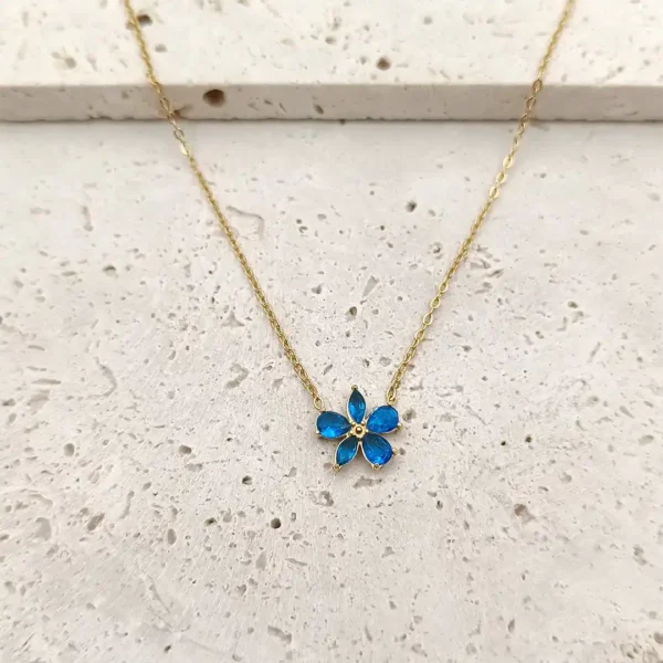 Collier femme doré en acier avec pendentif fleur en verre bleu.