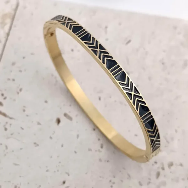 Bracelets jonc en acier doré avec motifs géométriques en émail noir pour femme.