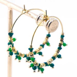 Boucles d’oreilles créoles en acier doré, décorées de perles vertes et de petites perles dorées, style élégant et raffiné.