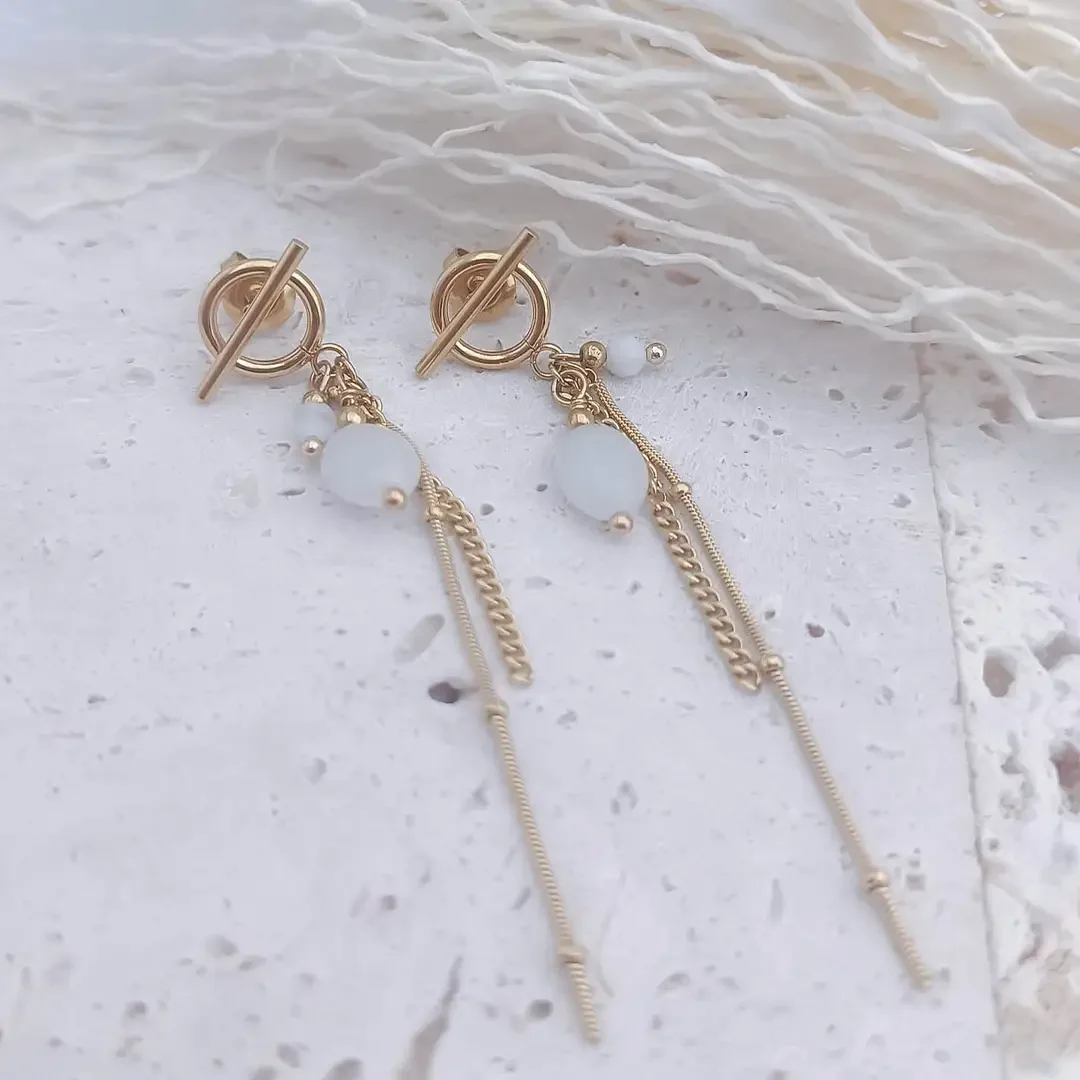 Boucles d'oreilles pendantes élégantes en plaqué or avec perles blanches naturelles et chaînes fines, bijou raffiné pour femme.