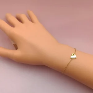 Bracelet fin en acier inoxydable doré, orné d’un pendentif cœur en nacre blanche avec une étoile ajourée.