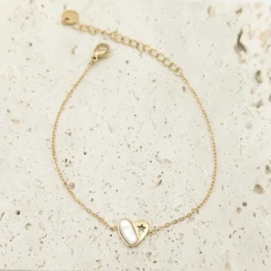 Bracelet fin en acier inoxydable doré, orné d’un pendentif cœur en nacre blanche avec une étoile ajourée.