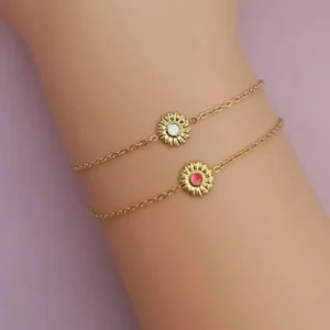 Bracelet pour enfant en acier doré avec une petite fleur au centre, ornée d’un cœur coloré fuchsia ou blanc, chaîne fine ajustable avec fermoir mousqueton