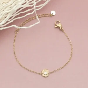 Bracelet pour enfant en acier doré avec une petite fleur au centre, ornée d’un cœur coloré blanc, chaîne fine ajustable avec fermoir mousqueton