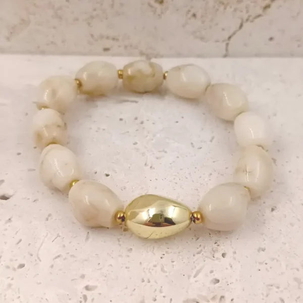 Bracelets en perles en résine ovales couleur ivoire avec une perle centrale dorée et acier