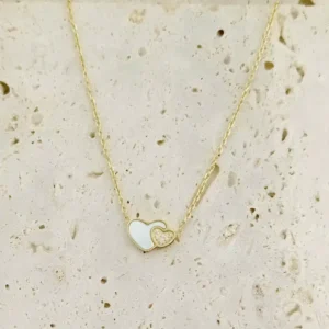 Collier mode femme en acier inoxydable doré, double cœur élégant avec nacre blanche et strass brillant.