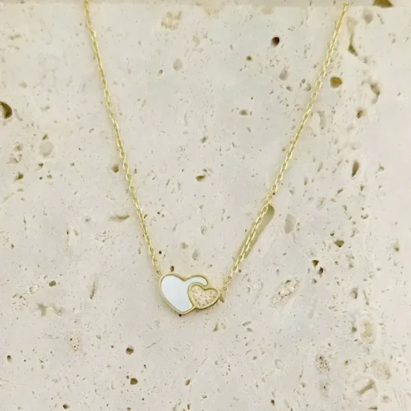 Collier mode femme en acier inoxydable doré, double cœur élégant avec nacre blanche et strass brillant.