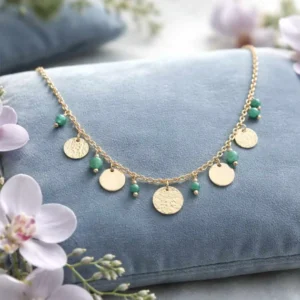 Collier femme en acier doré orné de pampilles rondes, martelées et de petites pierres ronds vertes