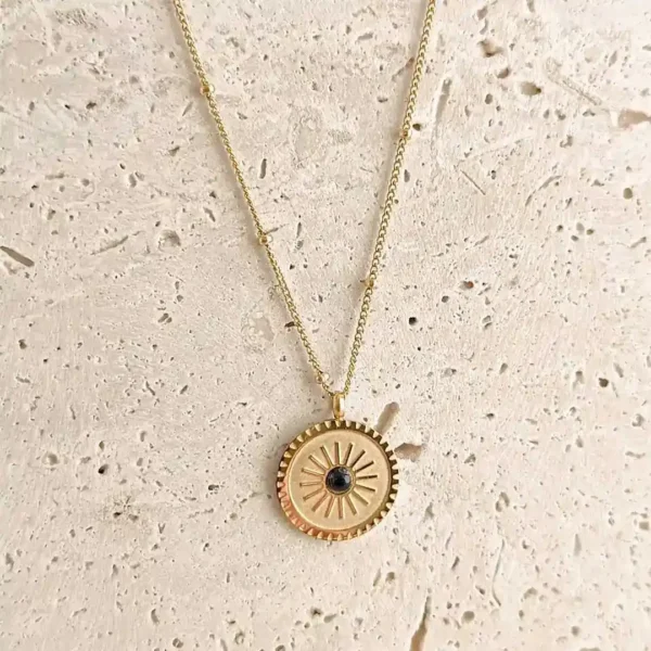 Collier en acier doré avec pendentif soleil et pierre noire au centre