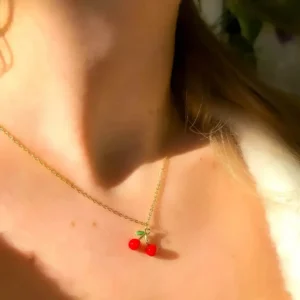 Collier acier doré avec pendentif en forme de cerise rouge et feuille verte émaillées