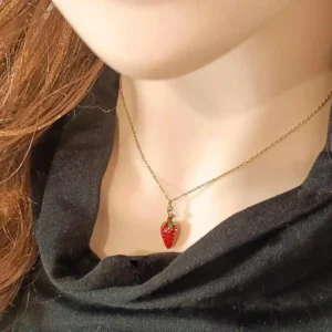 Collier doré avec pendentif en forme de fraise rouge émaillée