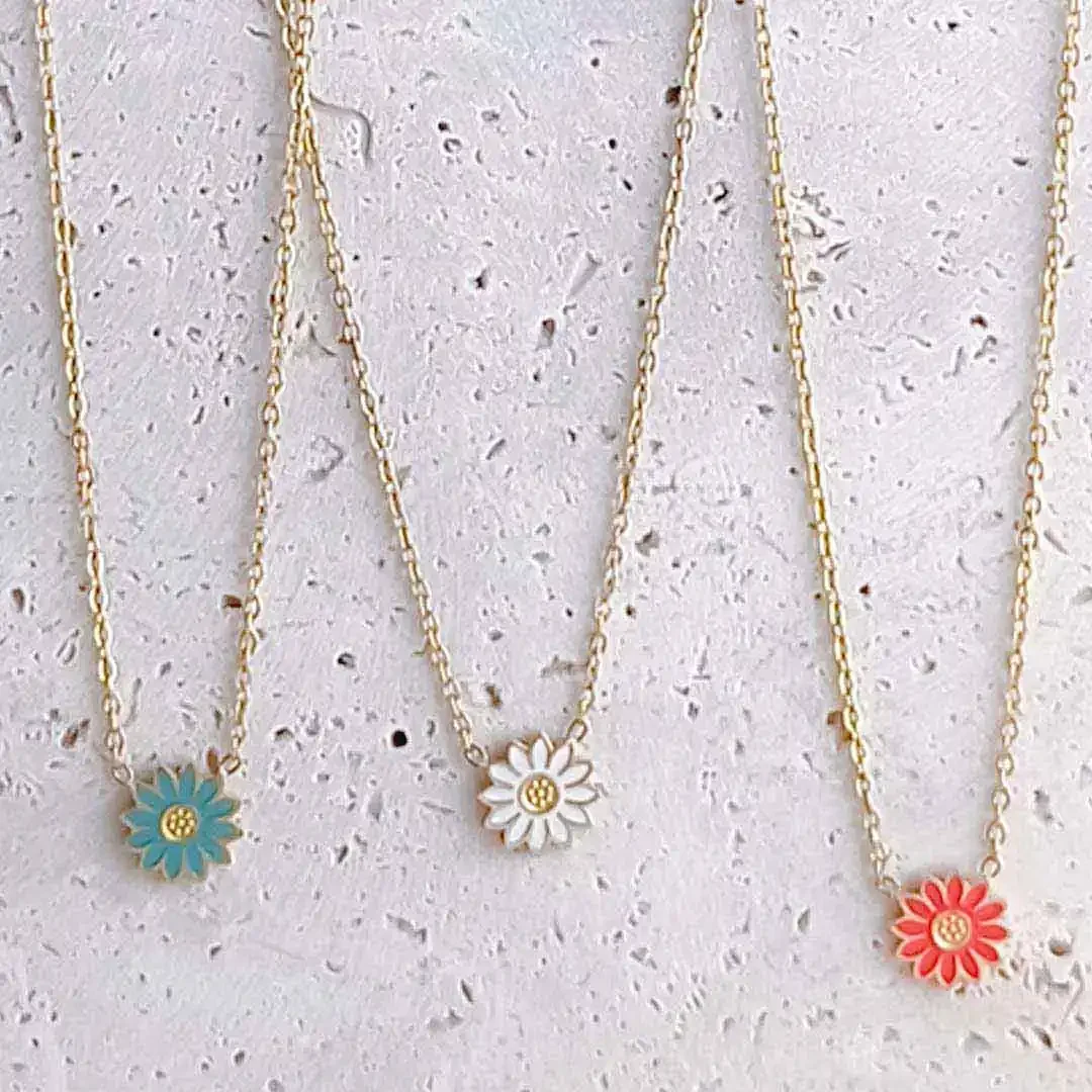 Colliers enfant en acier doré avec pendentifs fleurs colorées bleu, blanc et corail.