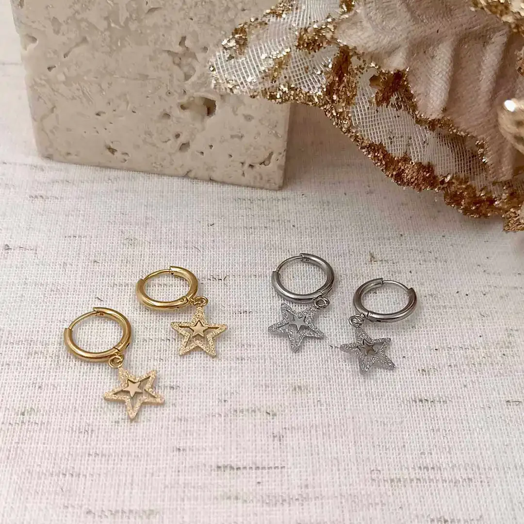 Boucles d’oreilles en acier inoxydable avec pendentifs étoile pailletée, disponibles en version dorée et argentée.