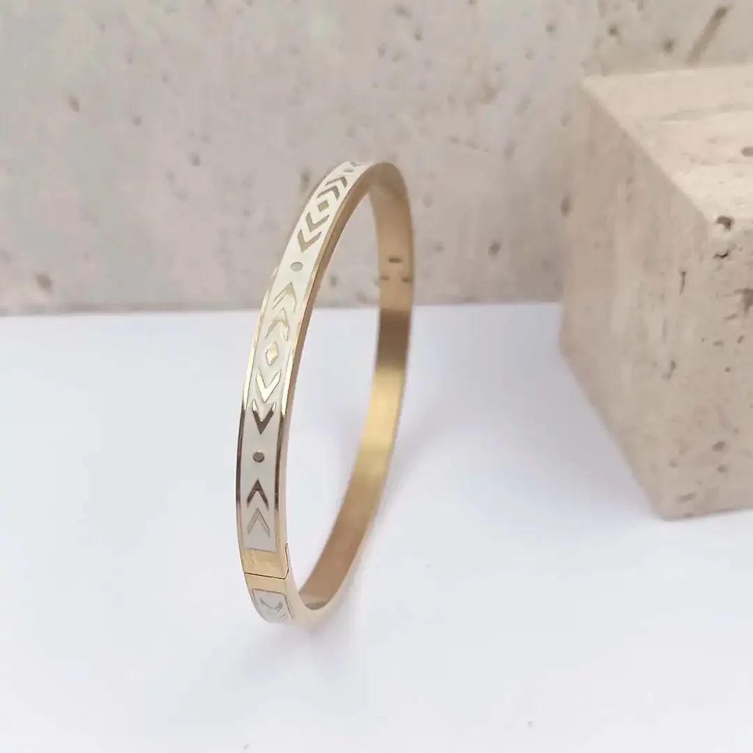 Bracelet jonc ovale en acier et émaillé coloré blanc et formes géométriques dorées