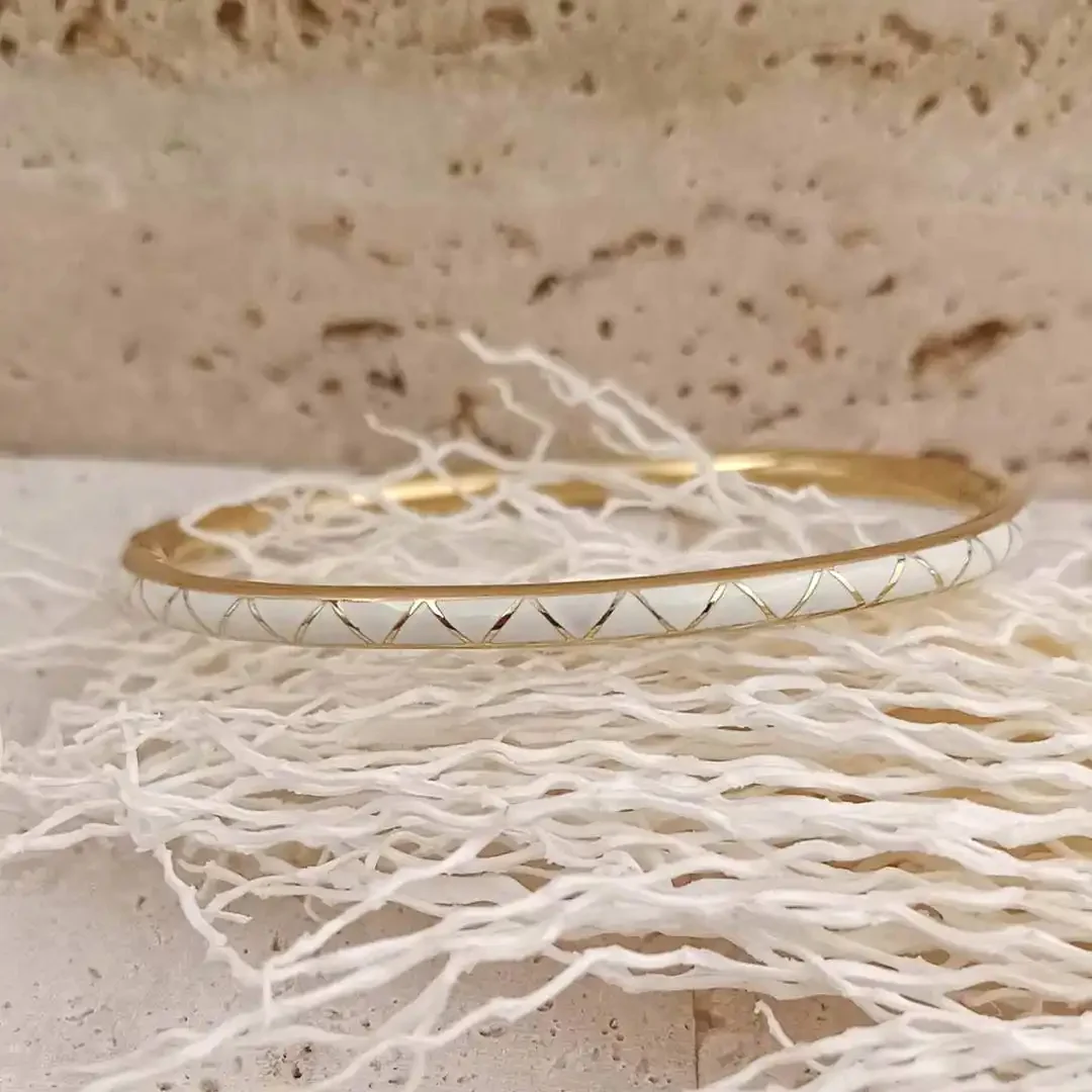 Bracelet jonc fermé fin en acier doré et émaillé blanc avec formes géométriques dorées