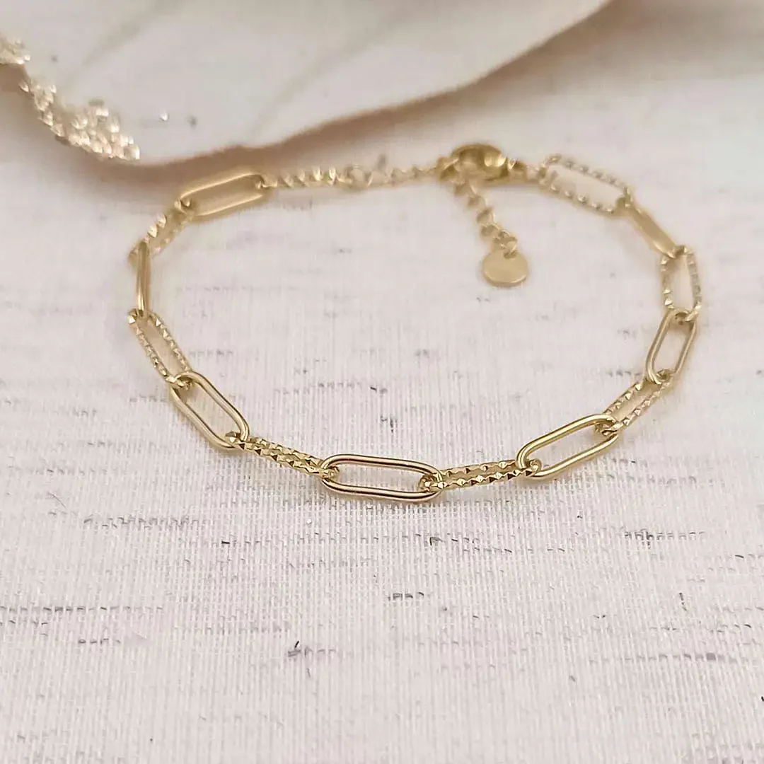 Bracelet en acier doré composé de maillons ovales dont certains sont martelés, idéal pour ajouter des charms.