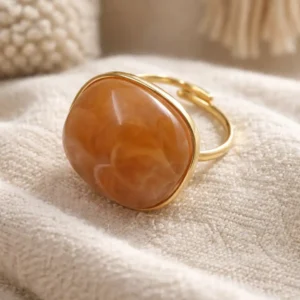 Bague ajustable en acier doré avec pierre en résine marron aux reflets doux.