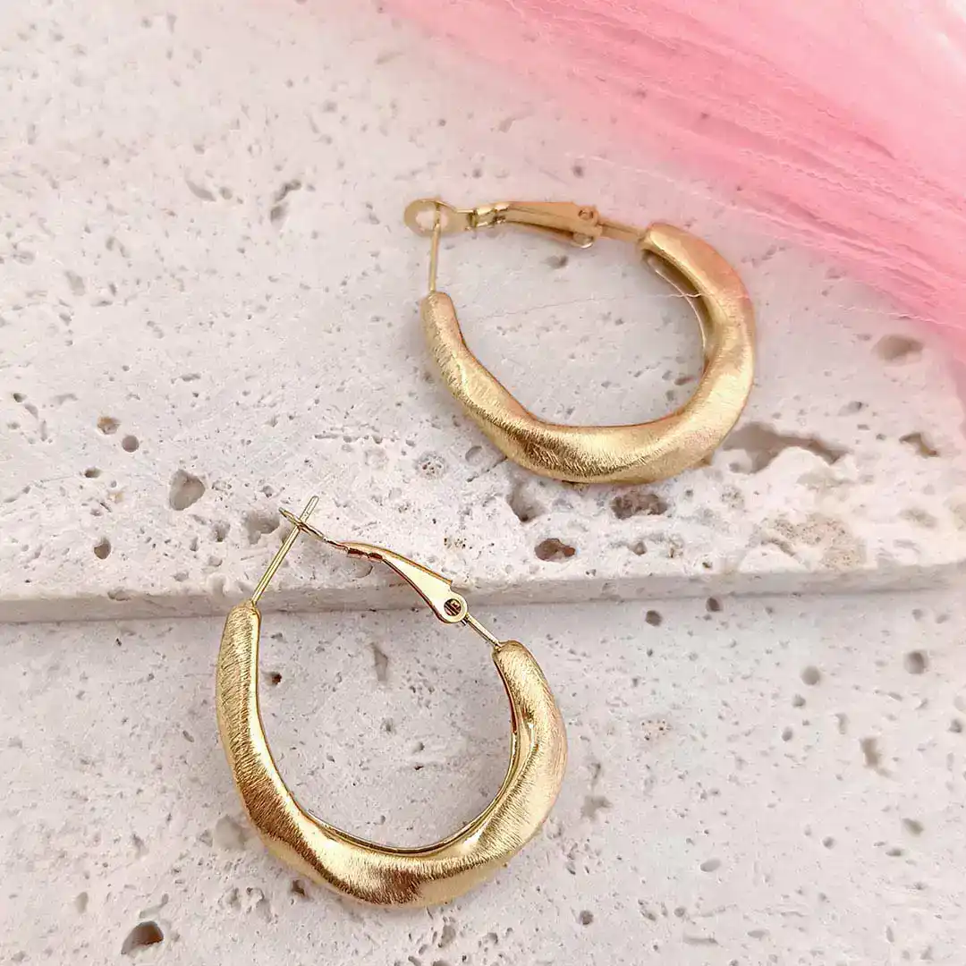 Boucles d’oreilles créoles en acier doré brossé avec fermeture à cliquet sécurisée, confortables, faciles à mettre et offrant une excellente tenue