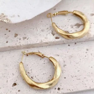 Boucles d’oreilles créoles en acier doré brossé avec fermeture à cliquet sécurisée, confortables, faciles à mettre et offrant une excellente tenue