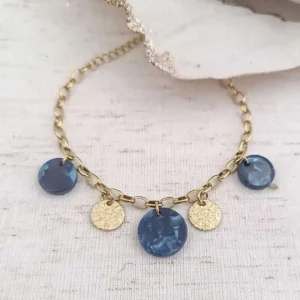 Bracelet à chaîne dorée à grosses mailles ovales avec breloques rondes en résine bleu et pampilles dorées martelées