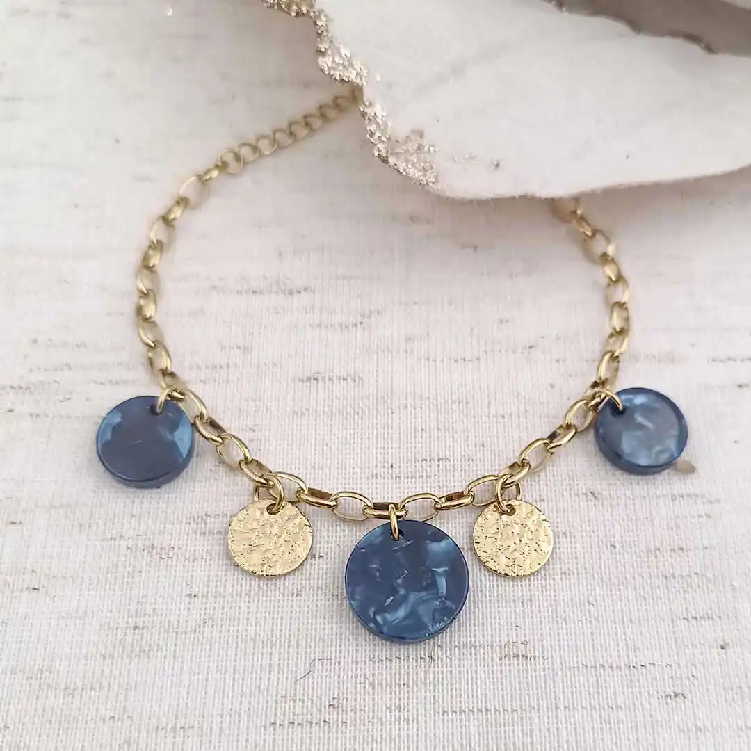 Bracelet à chaîne dorée à grosses mailles ovales avec breloques rondes en résine bleu et pampilles dorées martelées