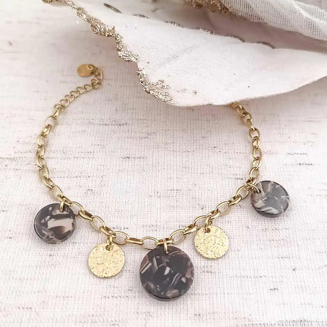 Bracelet à chaîne dorée à grosses mailles ovales avec breloques rondes en résine gris marron et pampilles dorées martelées