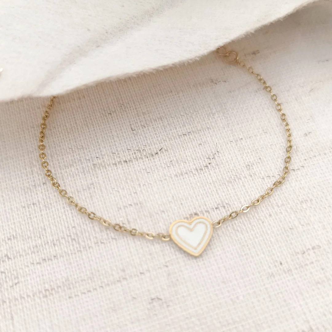Bracelet enfant en acier inoxydable doré avec cœur émaillée de couleur blanc.