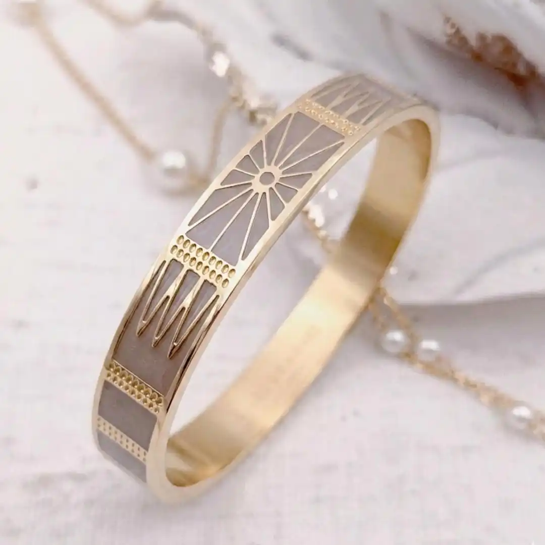 Bracelet jonc rigide large en acier doré avec motifs géométriques soleil gravés dorés