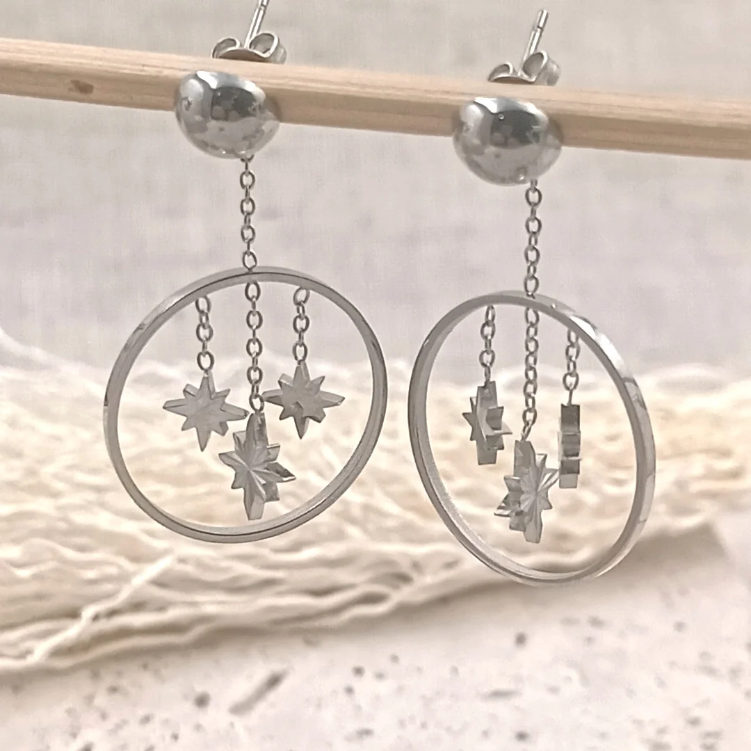Boucles d'oreilles pendantes argentées avec étoiles suspendues dans un cercle