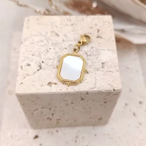 Charm rectangulaire en acier inoxydable doré avec insert en nacre blanche, finition vintage et fermoir mousqueton.