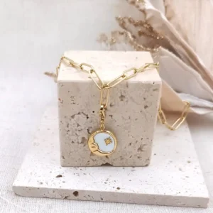 Charm personnalisé rond en acier inoxydable doré avec nacre blanche et motifs lune et étoile dorées, fermoir mousqueton intégré.