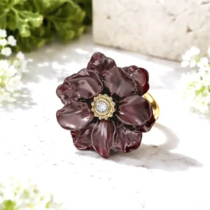 Bague ajustable en acier inoxydable doré avec fleur en résine marron. Son style floral intense et élégant apporte du caractère et une touche chic à votre look.