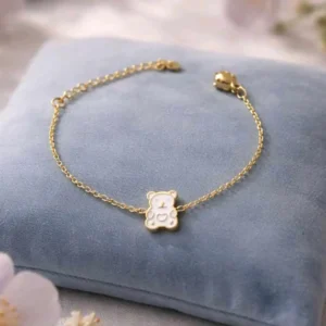 Bracelet enfant en acier inoxydable avec pendentif ourson blanc émaillé sur chaîne fine dorée