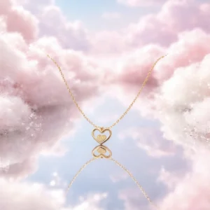 Collier en acier inoxydable doré avec pendentif cœur ajouré et petit cœur central.