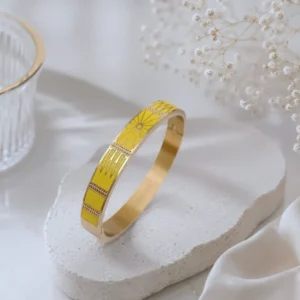 Bracelet jonc femme en acier inoxydable doré avec émail jaune lumineux et motifs géométriques élégants.