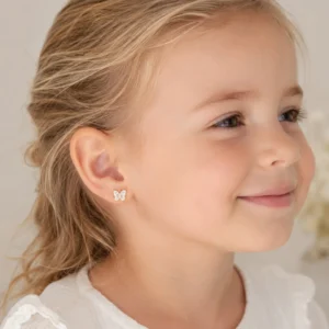 Boucles d'oreilles enfant acier inoxydable papillon blanc portées par une petite fille