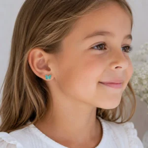 Boucles d'oreilles enfant acier inoxydable papillon turquoise portées par une petite fille
