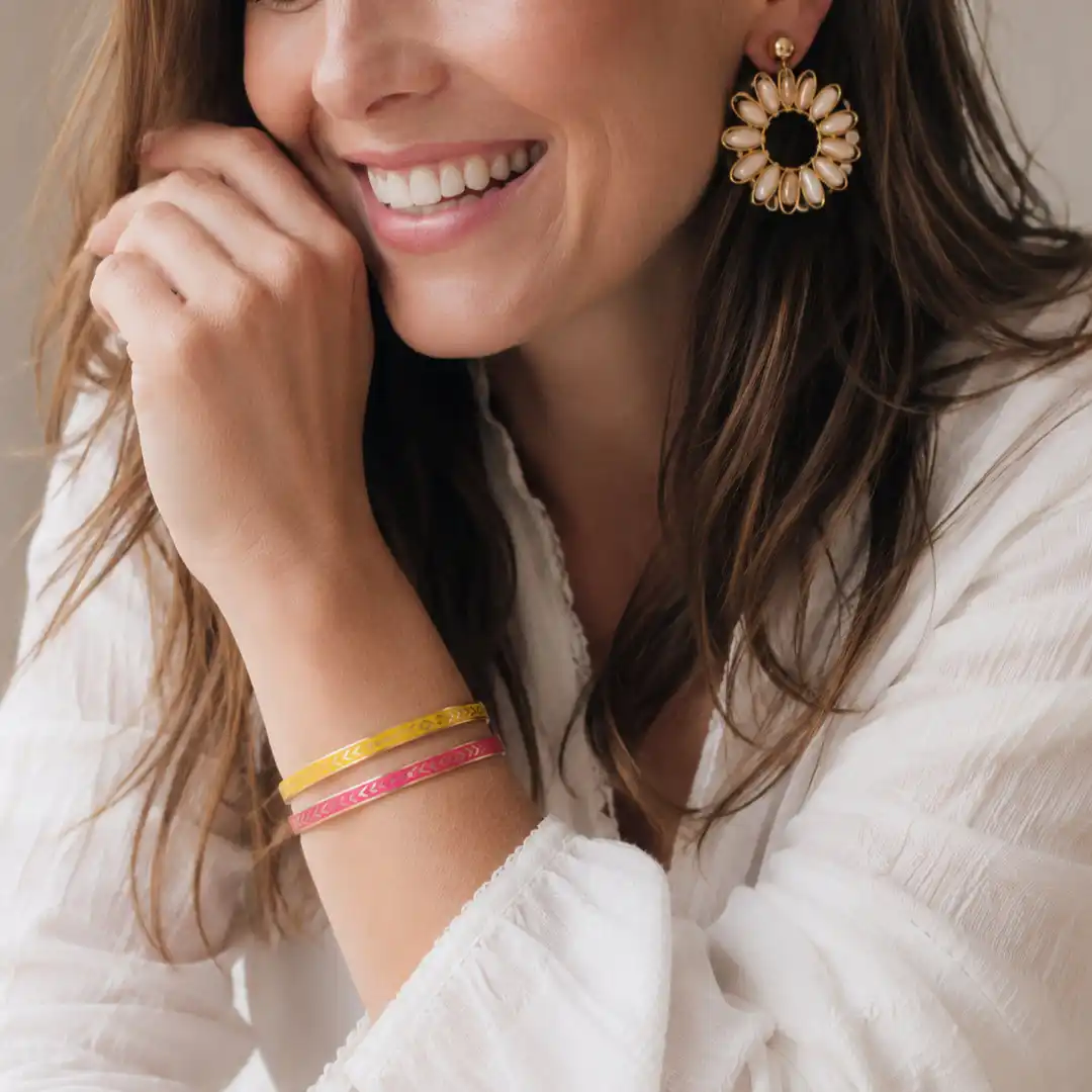 Bracelets joncs acier inoxydable dorés émaillés fuchsia et jaune portés au poignet