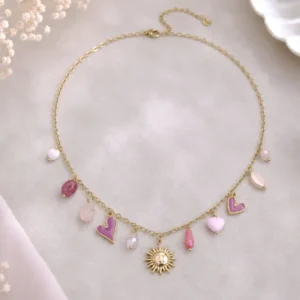 Collier soleil en acier inoxydable doré avec cœurs émaillés rose et fuchsia, perles roses et pendentif soleil