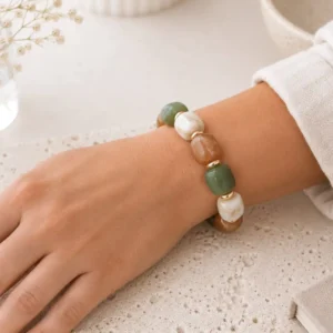 Bracelet élastique en résine vert et camel avec perles écrues et détails dorés