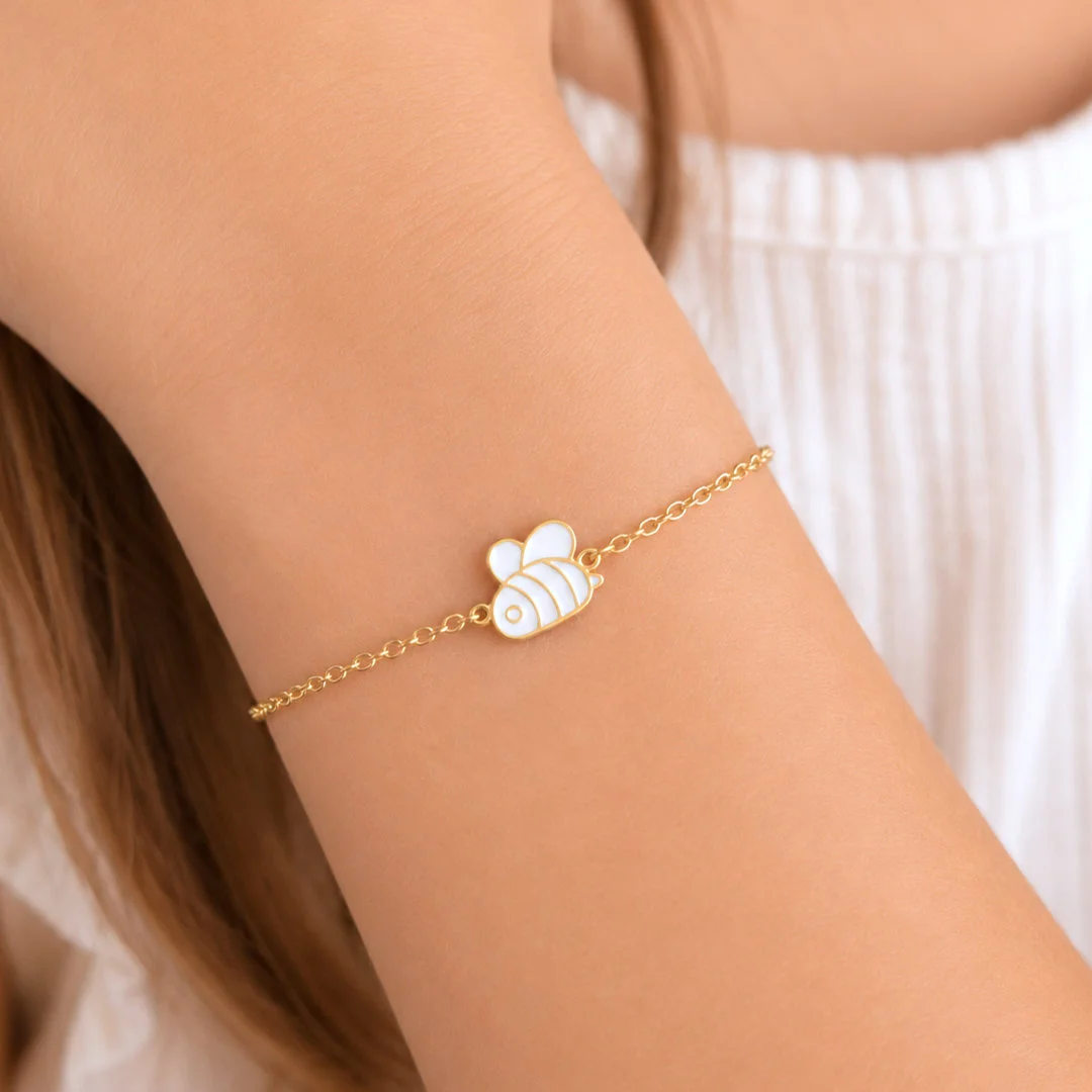 Bracelet enfant abeille en acier inoxydable doré et émail blanc au poignet