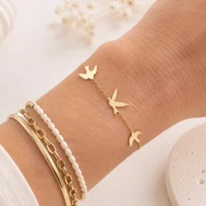 Bracelet hirondelles doré en acier inoxydable porté au poignet