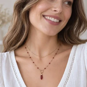 collier acier long perles rouges porté en accumulation