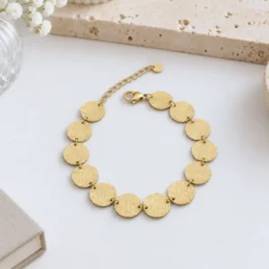 Bracelet doré à pastilles rondes texturées en acier inoxydable pour femme, avec fermoir mousqueton et chaînette d'extension.