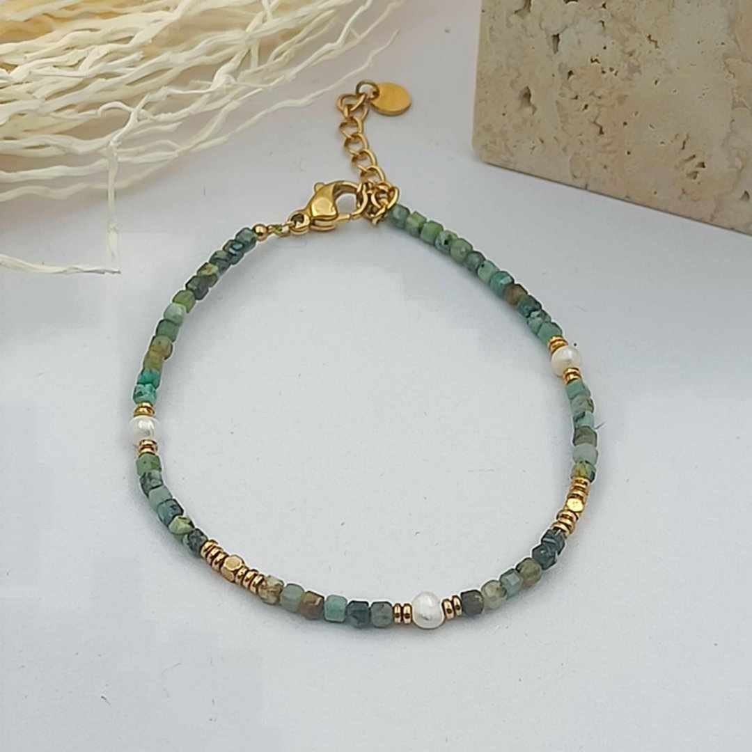 Bracelet petites pierres vertes cubiques d'environ 1 mm, trois perles blanches de 2 mm et intercalaires dorés.